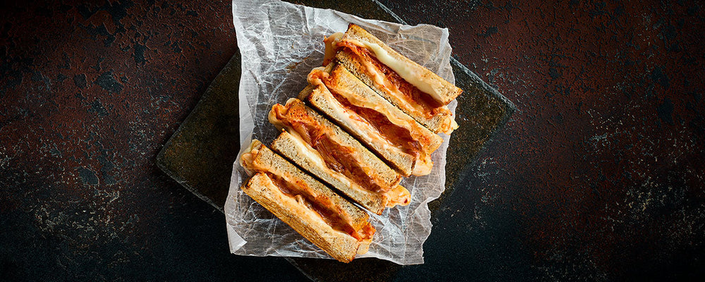 Billede af toasten, skåret i halve og serveret på madpapir. 