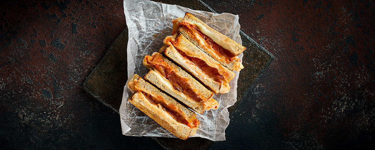 Billede af toasten, skåret i halve og serveret på madpapir. 