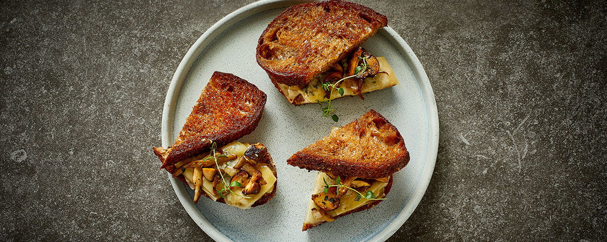 Billede af halve toast med svampe og sprødt brød. 