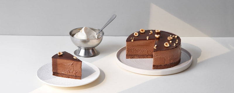 Billede af chokoladecheesecake, hvor der er skåret et stykke ud til servering. 
