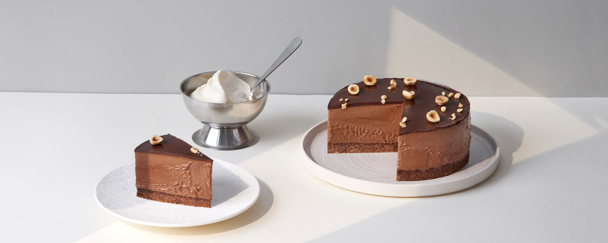 Billede af chokoladecheesecake, hvor der er skåret et stykke ud til servering. 