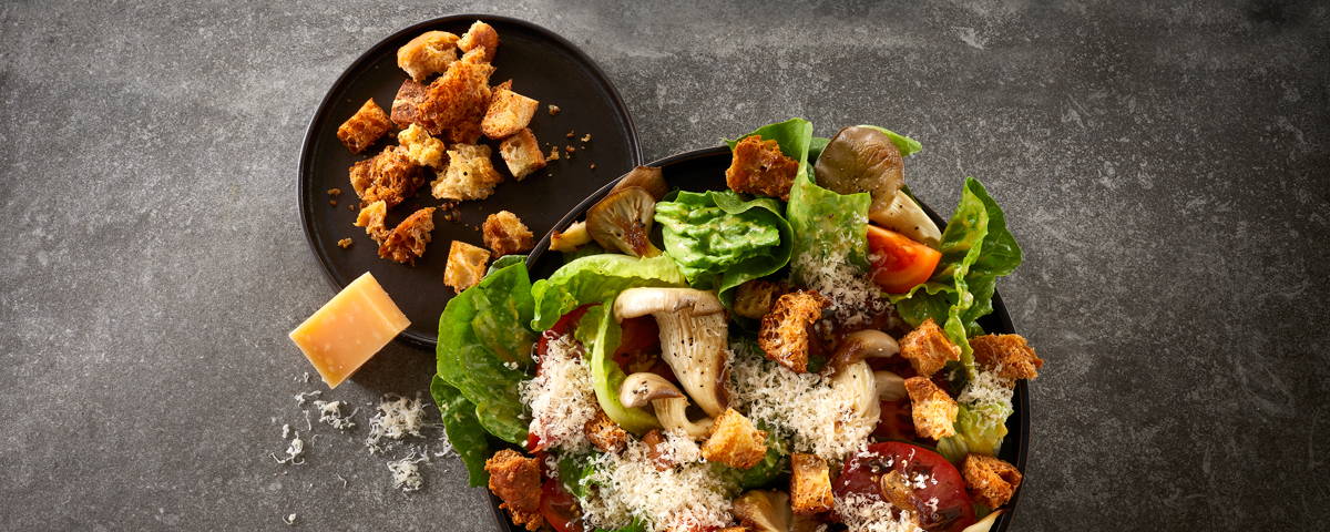 Billede af en sprød cesar salat, med osten Havgus revet henover. 