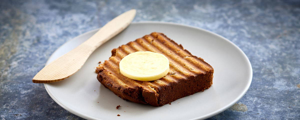 Billede af en skive ristet Banana bread med en skive smør på. 